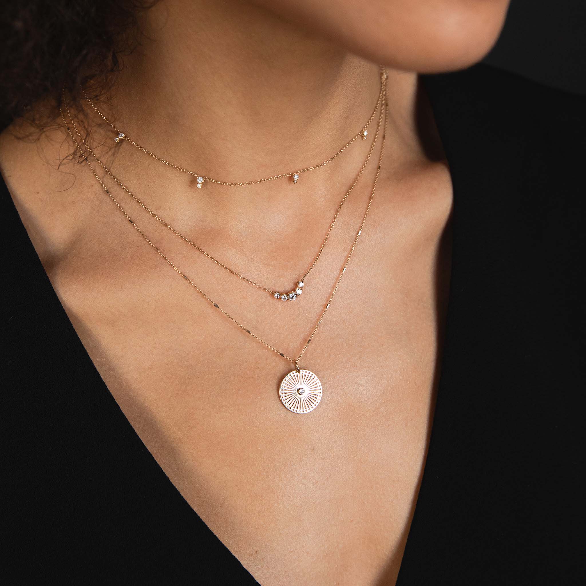 A Zoe Chicco trio of necklaces including a stacked stationed necklace, a 5 arc and a small sunbeam medallion necklace