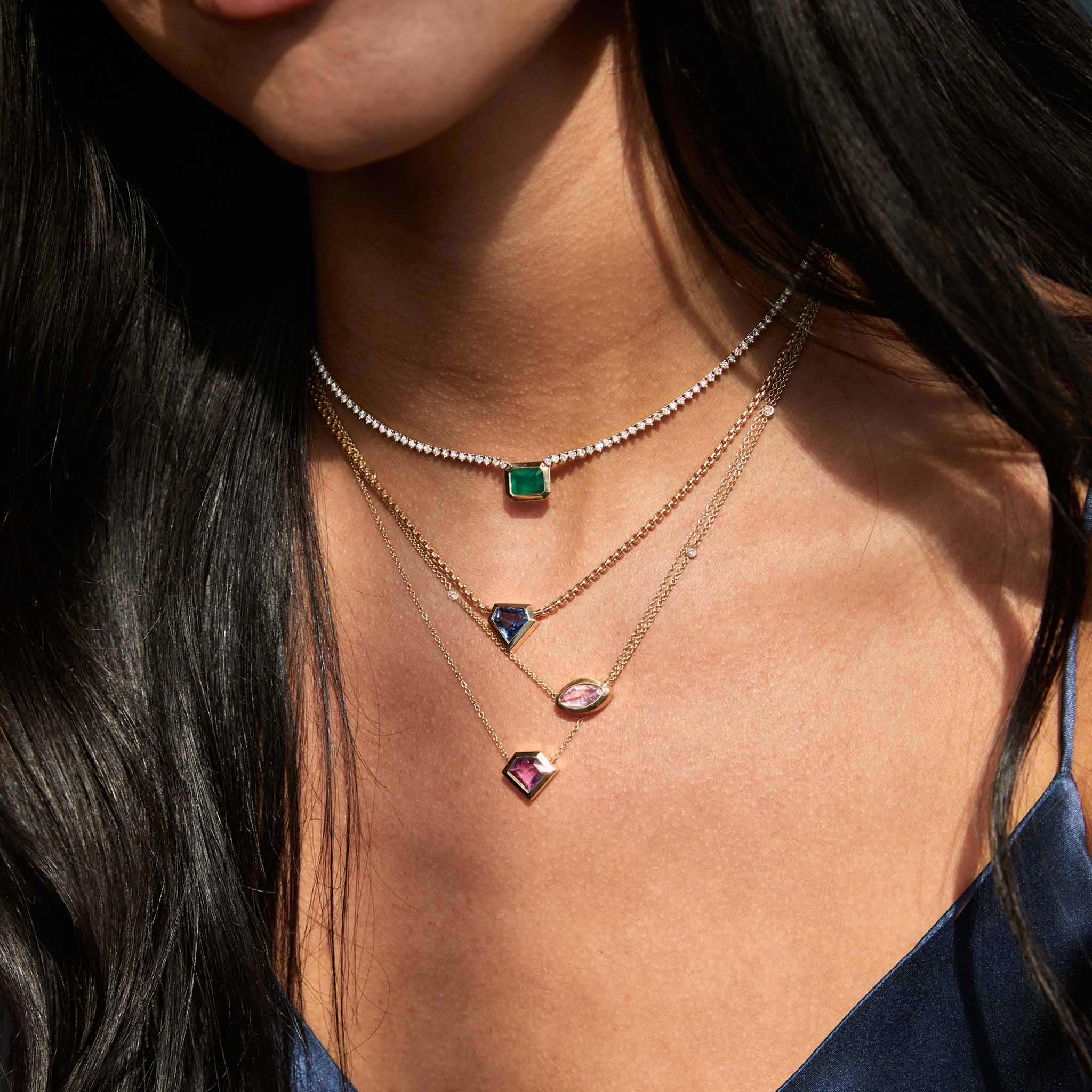 a woman in a navy camisole wearing a Zoë Chicco 14k Gold One of a Kind 1.38 ctw Shield Pink Sapphire Bezel Necklace layered with a 1.16 ctw Marquise Pink Sapphire with Floating Diamond Stations Necklace and two other one of a kind gemstone necklaces