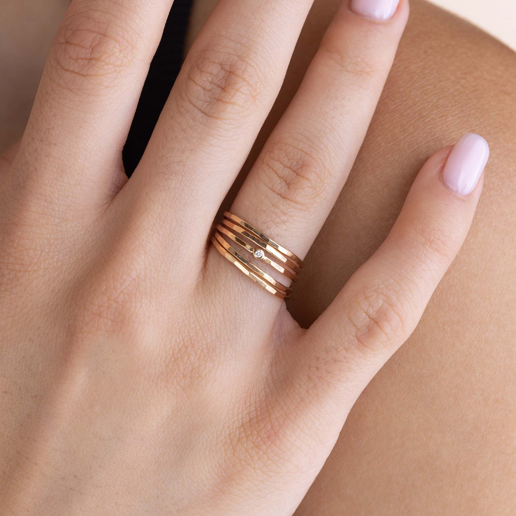 A woman is wearing Zoe Chicco's Set of 5 14k Hammered Gold & Diamond Rings