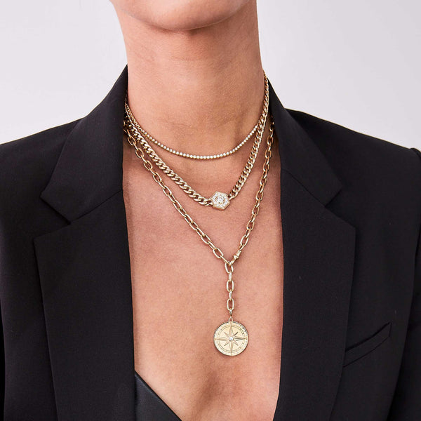 woman in a black blazer wearing a Zoë Chicco 14k Gold Large Compass Medallion Adjustable XL Square Oval Chain Necklace layered with two diamond necklaces