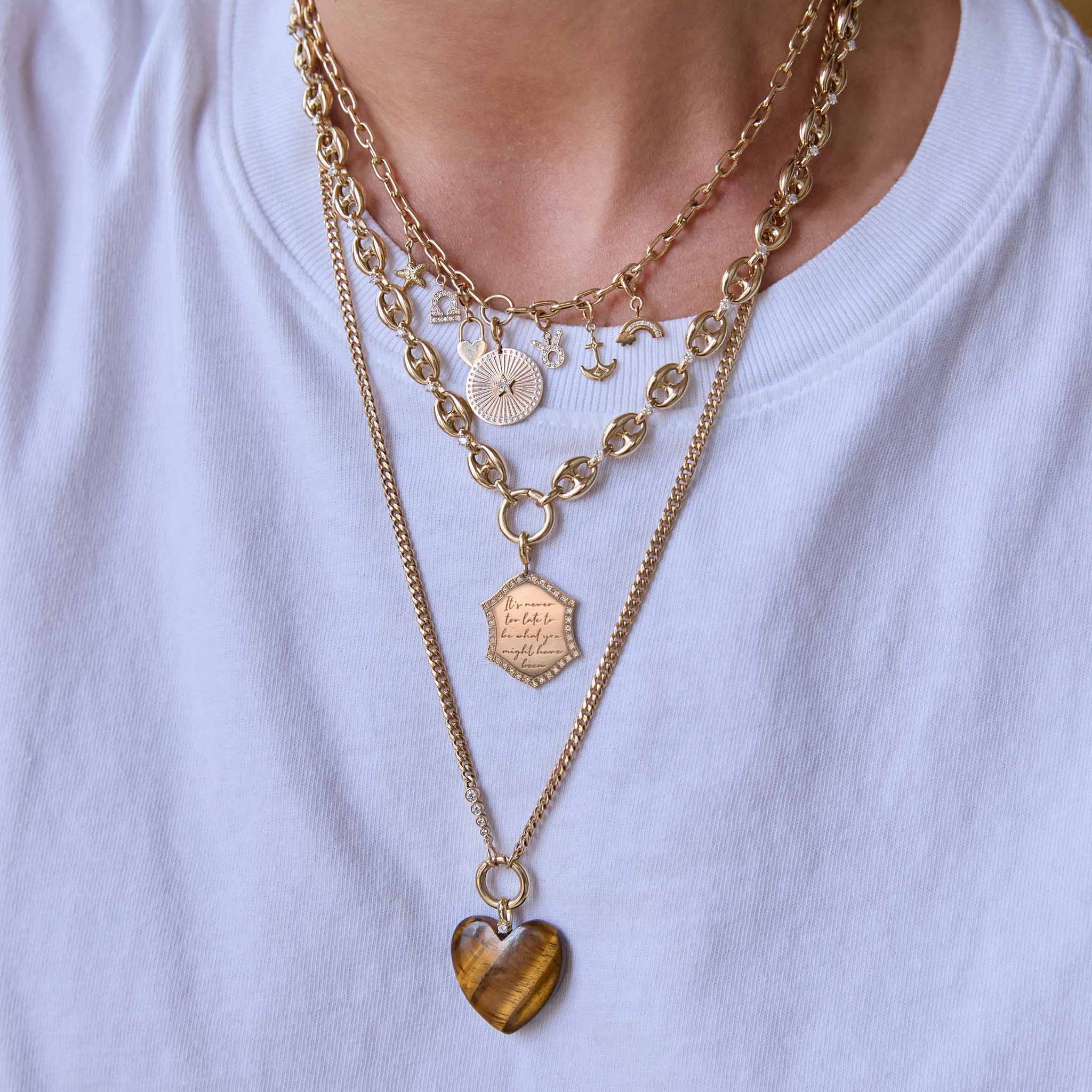 Layered 14k gold Zoe Chicco charm necklaces with diamonds and a tiger eye heart-shaped gemstone