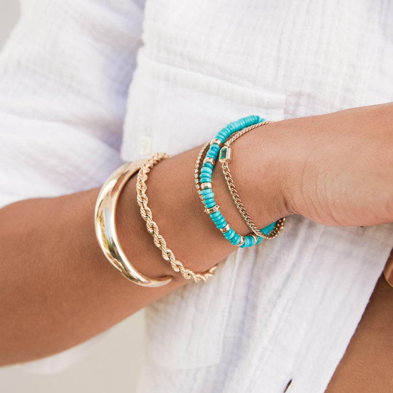 woman in a white shirt wearing a Zoë Chicco 14k Gold Large Rope Chain Bracelet and  Zoë Chicco 14k Gold & Turquoise Rondelle Bead Bracelet with 2 Prong Diamonds layered together on her wrist