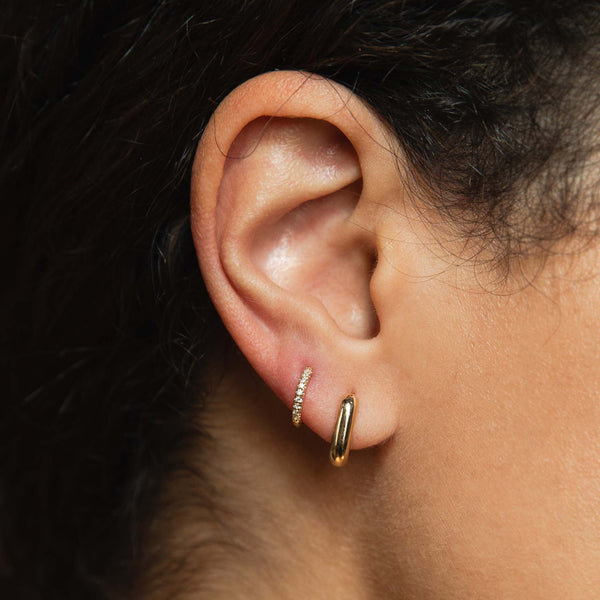 woman's ear with 14k Small Oval & Pave Diamond Hinge Huggie Set 