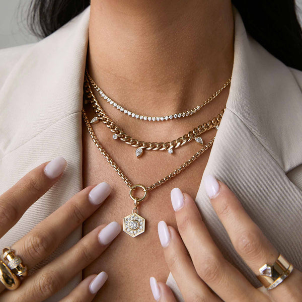 a woman in a beige grey blazer wearing a Zoë Chicco 14k Gold Alternating Pear & Round Diamond Large Curb Chain Necklace layered with a Diamond Tennis Segment Curb Chain Necklace