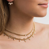 woman wearing a Zoë Chicco 14k Gold Graduated Prong & Pear Diamonds Large Curb Chain Necklace layered with another curb chain necklace