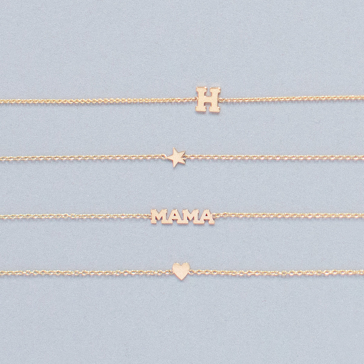 flat lay of 4 Zoe Chicco 14 karat gold Itty Bitty bracelets