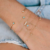 Zoë Chicco 14kt Gold 3 Diamond Bezel Bracelet stacked with other diamond and turquoise stone bracelets on a wrist