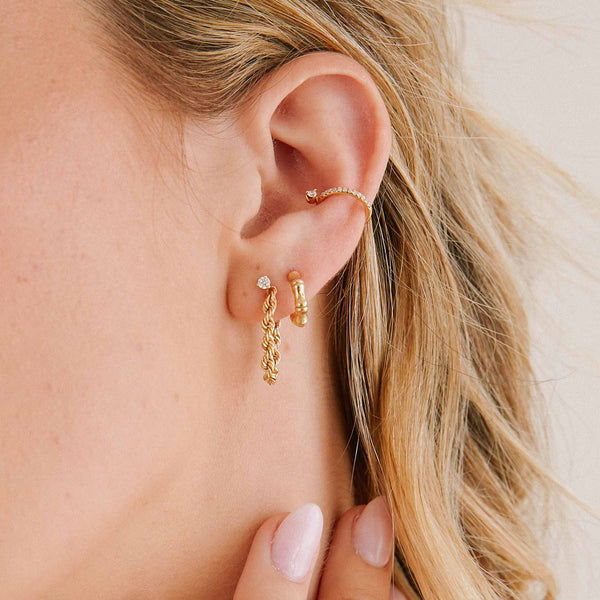 woman's ear wearing a Zoë Chicco 14k Gold Medium Rope Chain Huggie Earring with a Bamboo Huggie Hoop