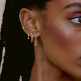 close up of woman's ear wearing Zoë Chicco 14k Gold 5 Linked Graduated Prong Diamond Drop Earrings