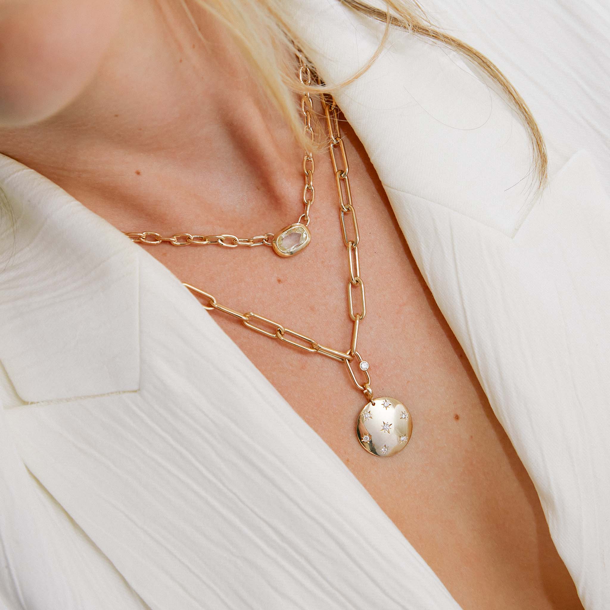 woman in a white collared top wearing a Zoë Chicco 14k Gold Single Diamond Bezel Large Paperclip Chain Necklace with a Aura disc charm pendant hanging from the center link