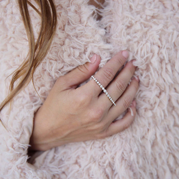 Woman in fuzzy pink jacket wearing a Zoë Chicco 14k Gold Diamond Bezel Double Finger Ring on her hand