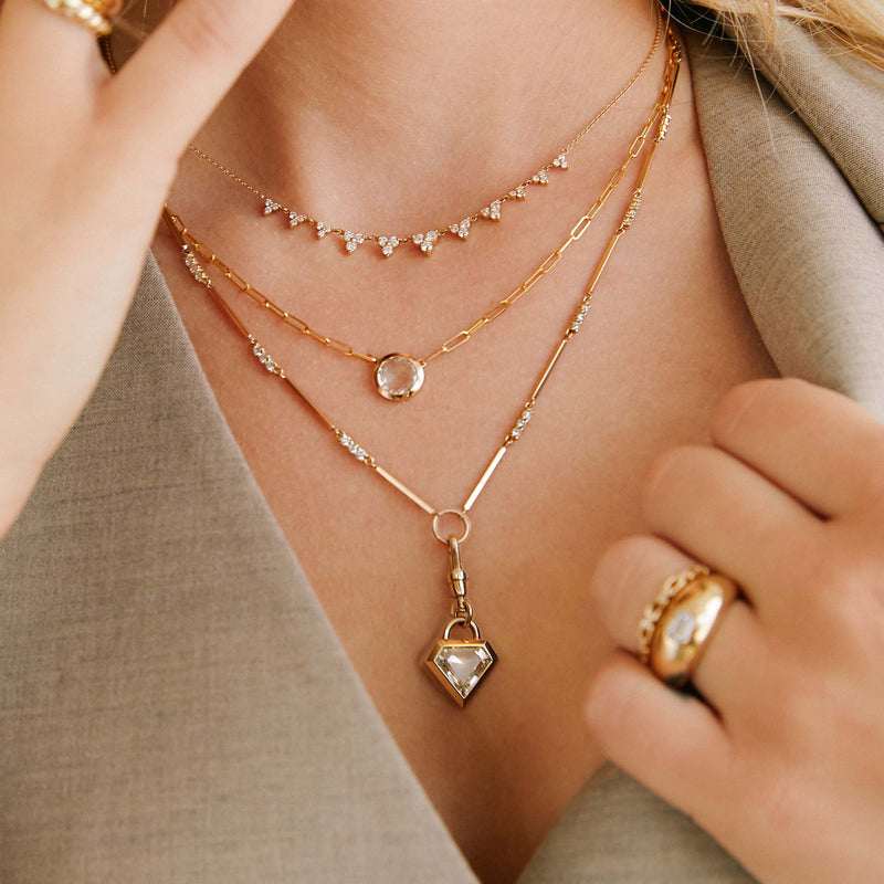 cropped view of a woman in a grey vest and jacket wearing a Zoë Chicco 14k Gold One of a Kind .84 ctw Rose Cut Round Diamond on Small Paperclip Chain Necklace layered with two diamond necklaces