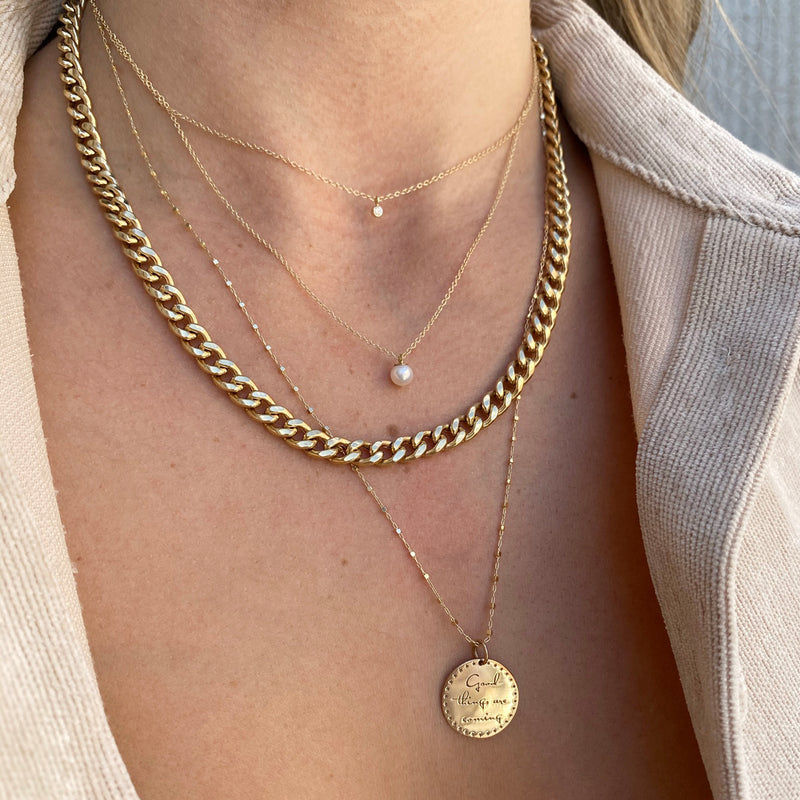 woman wearing Zoë Chicco 14kt Gold Large Curb Chain Necklace layered with three other necklaces