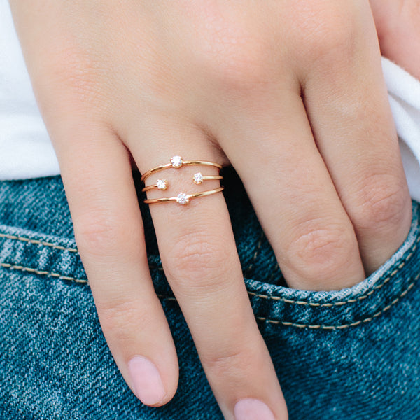 woman's hand in pocket wearing a Zoë Chicco 14k Gold Prong Diamond Triple Open Band Ring on her ring finger