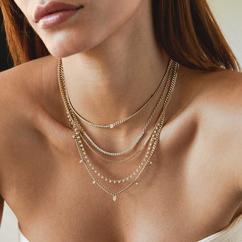 close up of a woman's neck wearing a Zoë Chicco 14k Gold Diamond Tennis Segment Rolo Chain Necklace layered with a 14k Floating Diamond Mixed Curb Chain & Diamond Tennis Necklace and 14k Linked Prong Diamond Tennis Necklace and 14k Mixed Cut Diamond Small Curb Chain Necklace