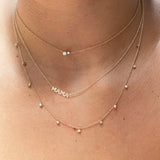 woman's neck wearing Zoë Chicco 14kt Yellow Gold Itty Bitty MAMA Necklace layered with two other diamond necklaces