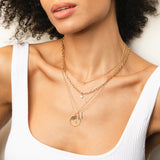 a woman wearing a Zoë Chicco 14k Gold Medium Sunbeam Medallion Disc Charm Pendant on a cable chain necklace
