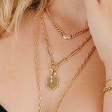 close up of woman wearing a Zoë Chicco 14k Gold Mixed Medium Square Oval & Large Paperclip Chain Round Enhancer Necklace with three charms attached