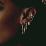 woman's ear wearing a Zoë Chicco 14k Gold Half Round Large Hoop Earring layered with other Heavy Metal earrings