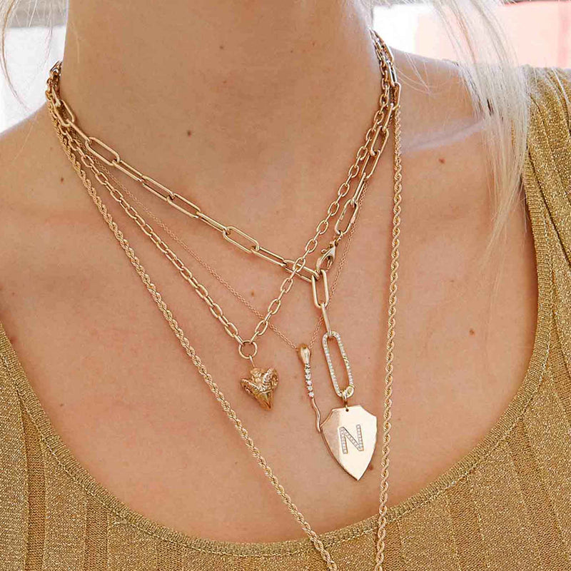 woman wearing a Zoë Chicco 14k Gold Large Paperclip Chain Oval Enhancer Necklace with a charm attached to the bottom
