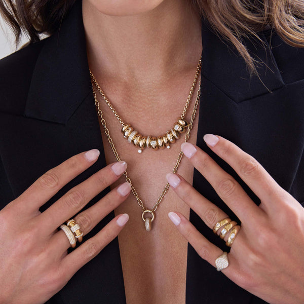 woman in a black blazer wearing a Zoë Chicco 14k Gold 13 Mixed Half Round Slide Bead Box Chain Necklace layered with a 14k Pavé Diamond Wide Half Round Slide Bead Round Enhancer Necklace