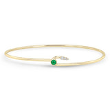 Zoe Chicco 14k gold wire cuff bracelet with a green emerald and 3 white diamonds on a white background