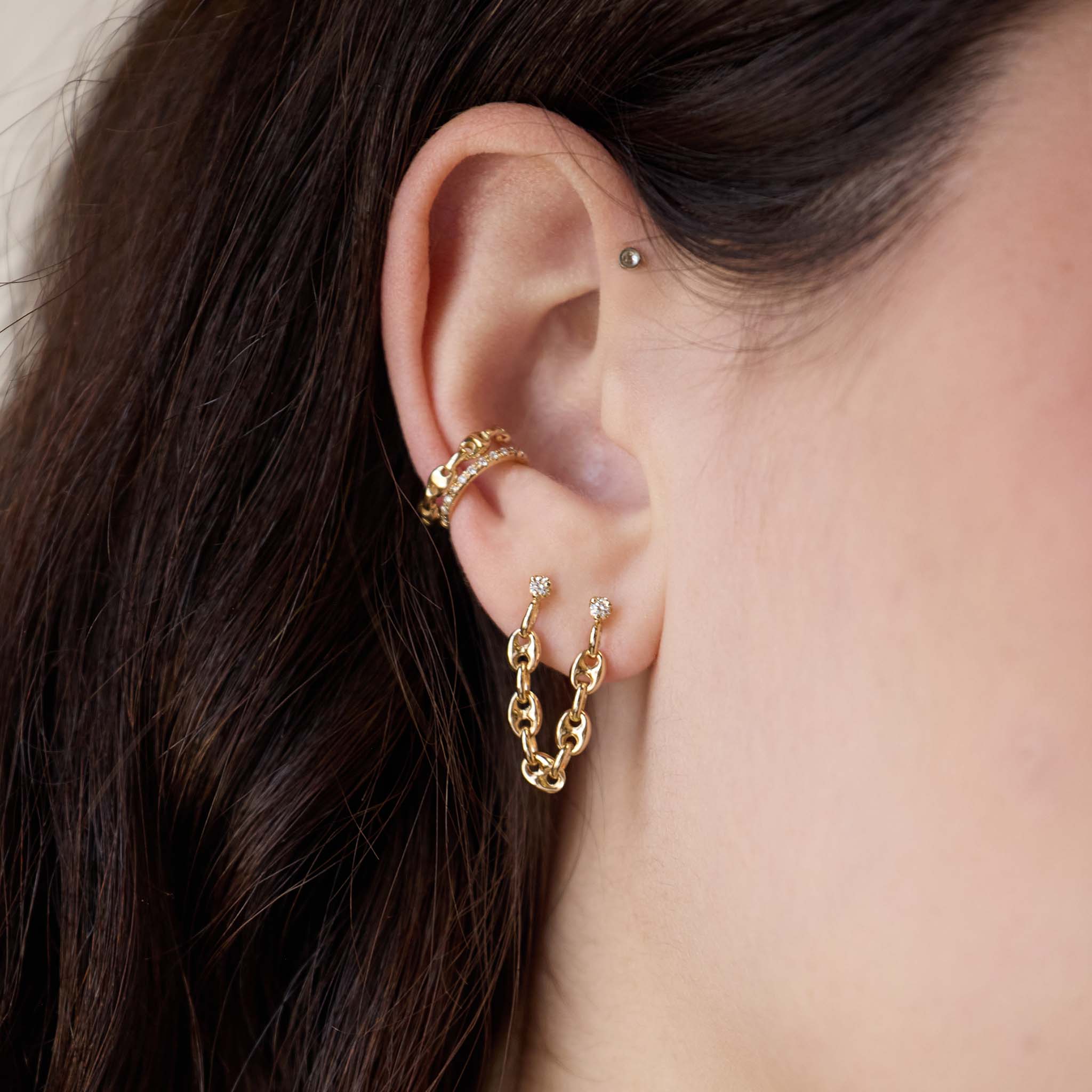 close up of a woman's ear wearing a Zoë Chicco 14k Gold Prong Diamond Double Stud Small Mariner Chain Earring with a 14k Gold Small Mariner Chain Ear Cuff and Pavé Diamond Ear Cuff