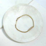 a Zoë Chicco 14k Gold Pavé Diamond MOM Small Curb Chain Bracelet sitting in a marble tray