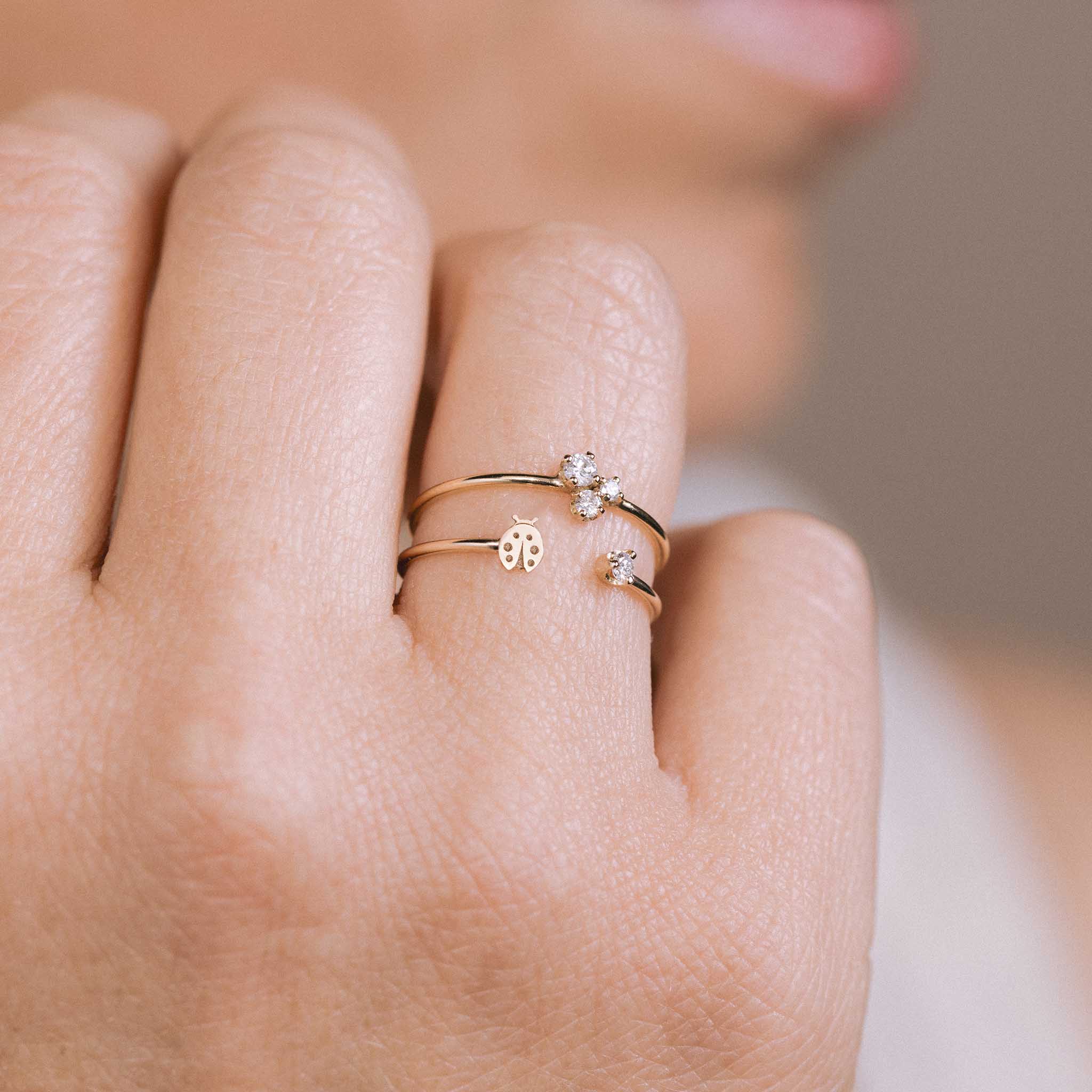 14k Itty Bitty Ladybug & Prong Diamond Open Ring worn on a woman's fingers with diamond trio ring.