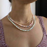 woman wearing an Zoë Chicco 14k Gold & Mixed Light Blue Opal Rondelle Bead Necklace with 3 Prong Diamonds layered with a 14k Gold & Mixed Pink Opal Rondelle Bead Necklace with 3 Prong Diamonds and a 14k Gold & Fire Opal Rondelle Bead Necklace with 3 Graduating Prong Diamonds