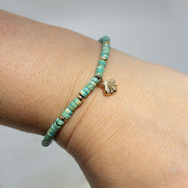 Zoe Chicco's 14k Gold & Light Turquoise Heishi Bead Seashell Charm Bracelet on a model's wrist