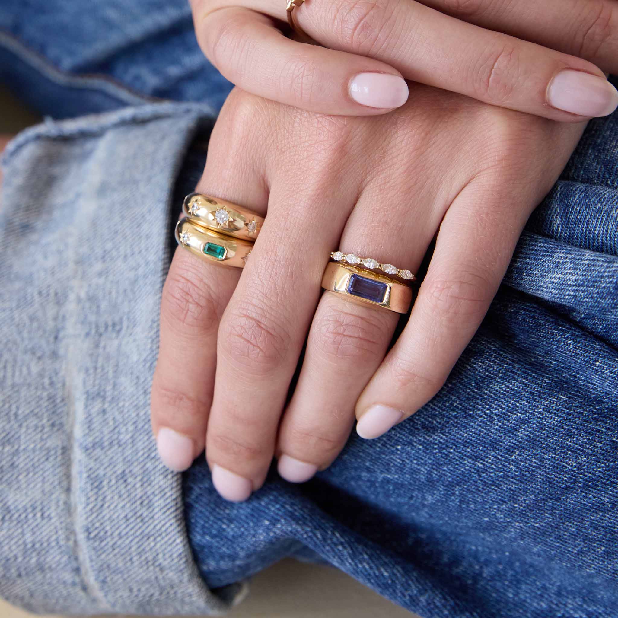 Zoe Chicco 14K green and blue gemstone rings with diamonds on a womans hand with a denim background