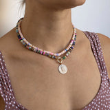 woman in a polka dot top wearing a Zoë Chicco 14k Gold & Mixed Pink Opal Rondelle Bead Necklace layered with a 14k Mixed Dark Gemstone Rondelle Bead Round Enhancer Necklace with a Pavé Diamond Hamsa Sunbeam Medallion Clip On Pendant hanging from the enhancer