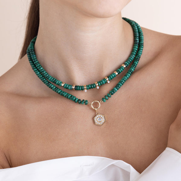 woman in a white off shoulder top wearing a Zoë Chicco 14k Gold & Malachite Rondelle Bead Necklace with 3 Prong Diamonds layered with a 14k Malachite Rondelle Bead Round Enhancer Necklace with a Diamond Hexagon Halo Charm clipped onto the enhancer