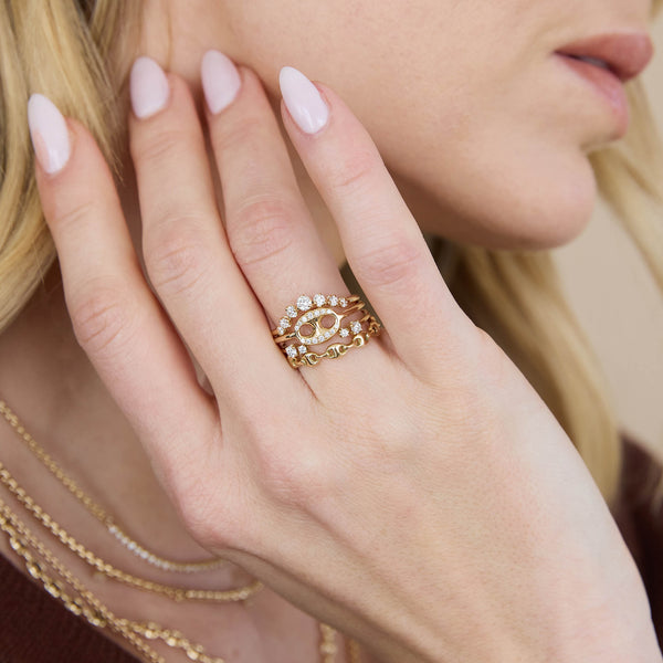 woman's hand resting against her neck wearing a Zoë Chicco 14k Gold Single Pavé Diamond Large Mariner Link Ring stacked with a 14k Graduated Prong Diamond Curved Bar Ring, 14k Double Mixed Prong Diamond Open Ring, and a 14k Gold Small Puffed Mariner Link Eternity Ring 