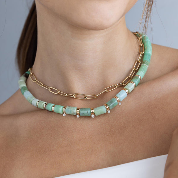 a woman is wearing Zoe Chicco's 14k Gold & Chrysoprase Tube Bead Necklace with 5 Prong Diamonds and Large Paperclip Chain Necklace.