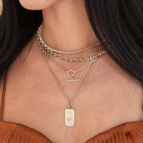 woman wearing a Zoë Chicco 14k Gold Queen Bee Large Square Edge Dog Tag Clip On Charm Pendant hanging from a curb chain necklace