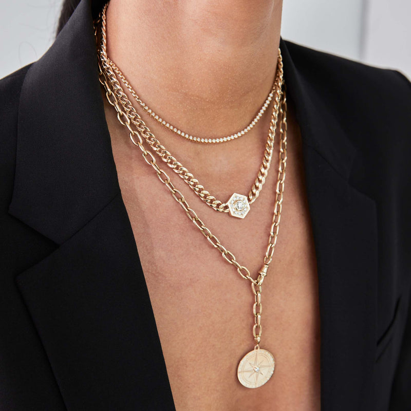 close up of a woman in a black blazer wearing a  Zoë Chicco 14k Gold Large Curb Chain Diamond Hexagon Halo Necklace layered with two necklaces