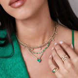 a woman in a green top wearing a Zoë Chicco 14k Gold Emerald & Diamond Tennis Segment Small Curb Chain Necklace layered with a one of a kind emerald necklace and two diamond necklaces
