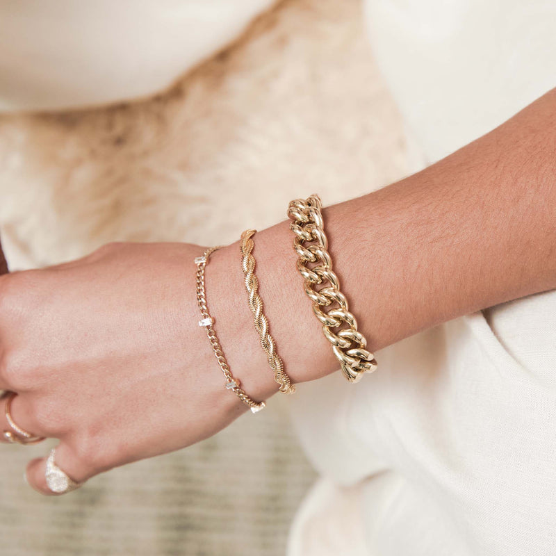 woman's arm wearing a Zoë Chicco 14k Gold XXL Thick Link Curb Chain Bracelet stacked with a 14k Small Curb Chain Bracelet with 5 Vertical Baguette Diamond Stations on her wrist