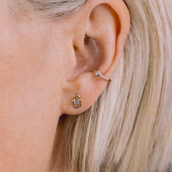 A woman with blonde hair is wearing the Zoe Chicco 14k Baguette Diamond Open Link Studs and 14k Princess & Pavé Diamond Ear Cuff