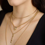 woman in a black top wearing a Zoë Chicco 14k Gold Wire Choker Necklace layered with a One of a Kind Pear Diamond Bezel Box Chain Necklace, 14k Pear Diamond Bezel Teardrop Rolo Chain Lariat Necklace