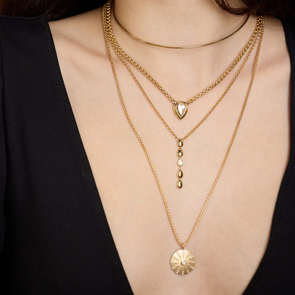 Zoe Chicco 14K Gold and diamond necklaces layered on a woman neck on a black background