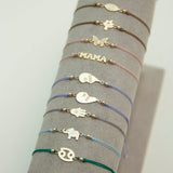 On a gray bracelet bar holds a variety of Zoe Chicco Cord bracelets 