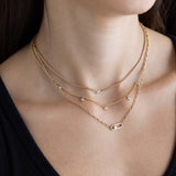 woman in a black top wearing a Zoë Chicco 14k Gold Nested Diamond Large Paperclip Link Square Oval Chain Necklace layered with a 14k Floating Diamond Small Box Chain Necklace and a 14k 5 Dangling Floating Diamond Station Bead Chain Necklace