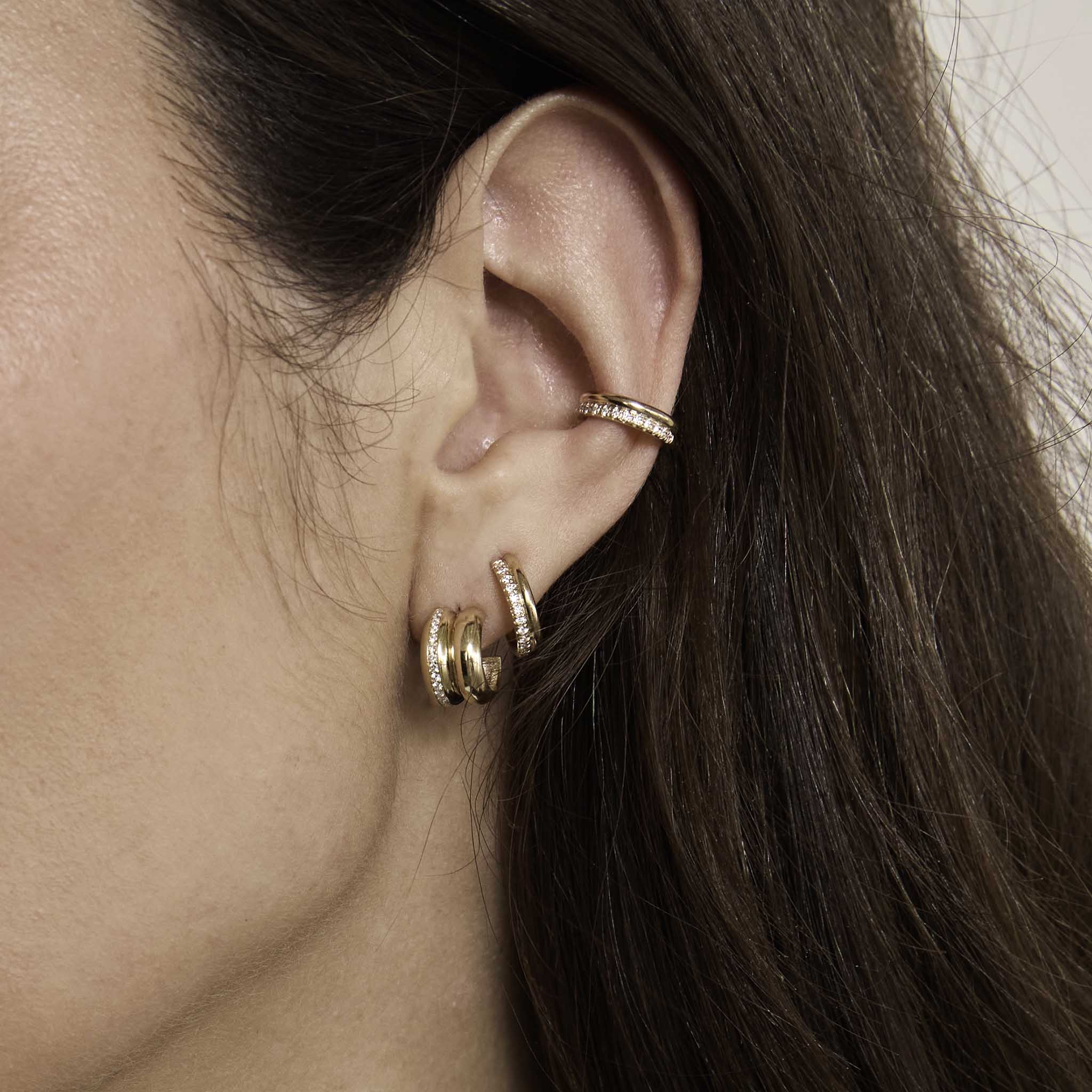 close up of a woman's ear wearing a Zoë Chicco 14k Gold & Pavé Diamond Double Row Huggie Hoop Earring in her second piercing and a 14k Gold & Pavé Diamond Line Double Chubby Huggie Hoop in her main piercing layered with a 14k Gold & Pavé Diamond Double Row Ear Cuff