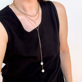 woman in a black tank top wearing a Zoë Chicco 14k Gold Double Baroque Pearl Wrap Around Lariat Necklace layered with two other necklaces