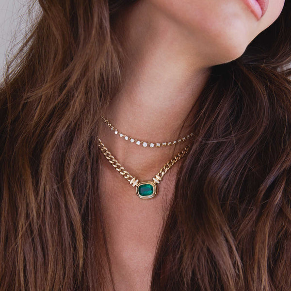 brunette woman wearing a One of a Kind Zoë Chicco 14k Gold Radiant Emerald Bezel Curb Chain Necklace layered with a Linked Graduated Prong Diamond Tennis Necklace