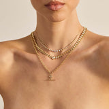 Layers of Zoe Chicco 14k gold and diamond necklaces worn on a woman's neck on a neutral background