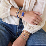Person wearing multiple bracelets on a casual outfit with a focus on jewelry featuring 14k Large Lapis & Pavé Diamond Bar Half Round Cuff